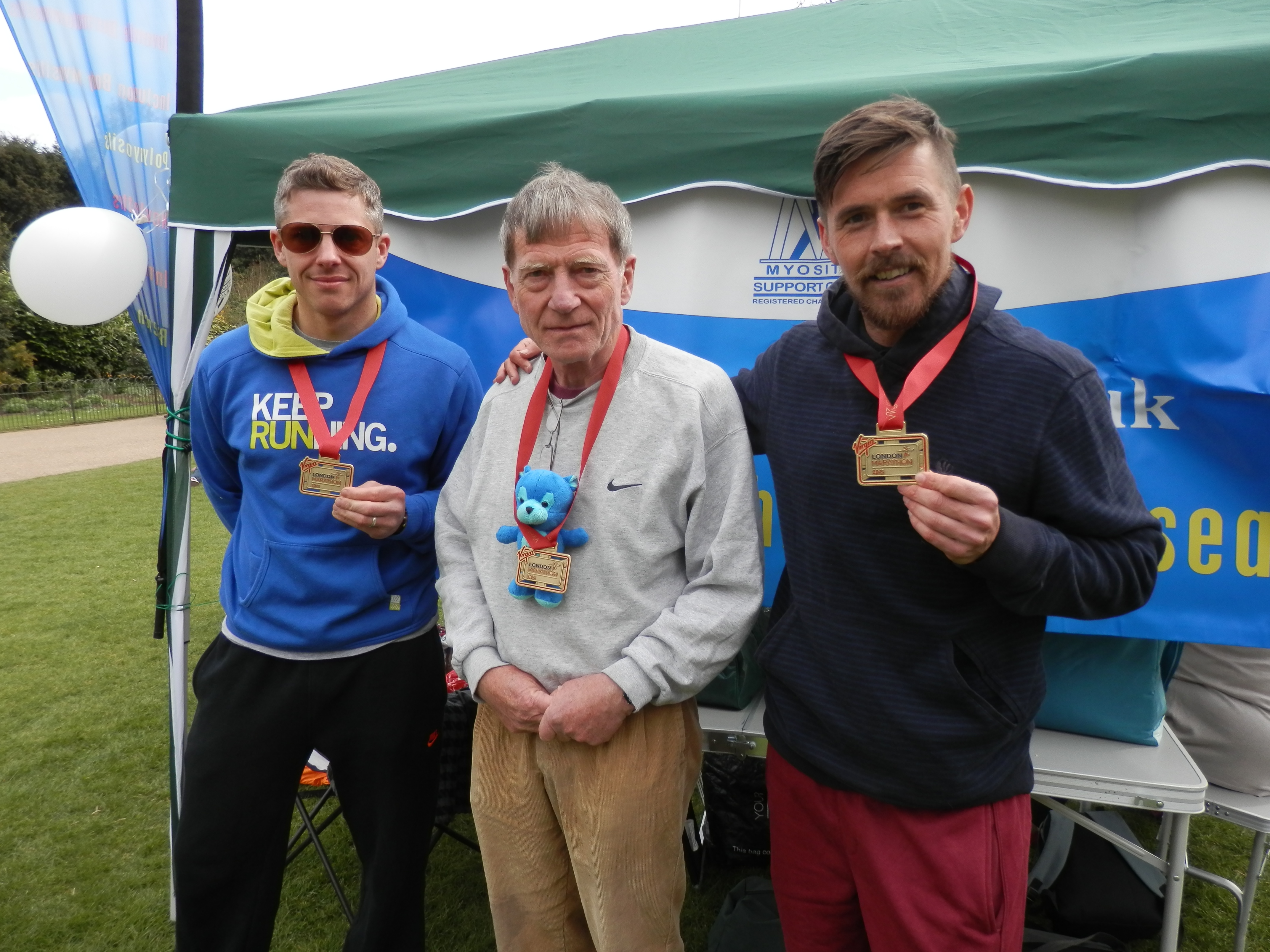 Three runners with their London Marathon medals.